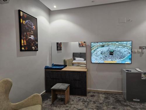 an office with a desk and a tv on a wall at غرفة شذا طيبة المخدومة Shaza Taibah Luxury Room in Al Madinah