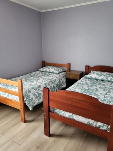 ein Zimmer mit 2 Betten und 2 Tischen und 2 Betten sidx sidx sidx sidx in der Unterkunft Cabañas kawi in Puerto Cisnes