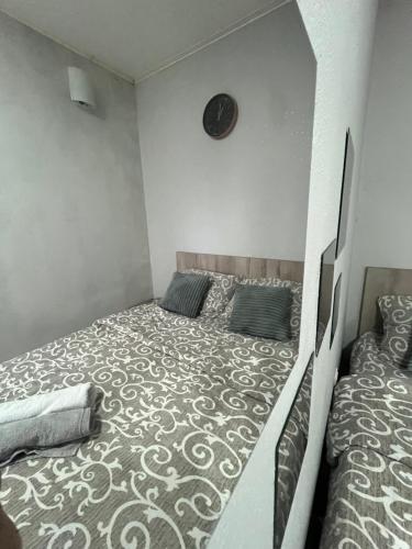 1 dormitorio con 1 cama y reloj en la pared en Stan na dan Paracin, en Paraćin