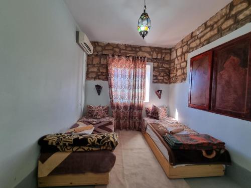 a room with two beds and a chandelier at Auberge Restaurant Telouet in Telouet