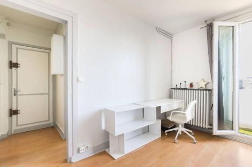 un bureau avec un bureau blanc et une chaise dans l'établissement Appart Plein Soleil Seine Paris 5ème Jardin Plantes, à Paris