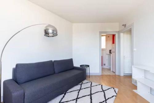 un salon avec un canapé bleu et un tapis dans l'établissement Appart Plein Soleil Seine Paris 5ème Jardin Plantes, à Paris