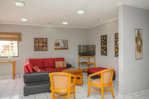 sala de estar con sofá y sillas en Aparthotel Guijarros, en Tegucigalpa