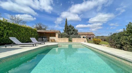 une piscine avec deux chaises et une maison dans l'établissement Le mas des 4 païs, à Saint-Marcel-dʼArdèche