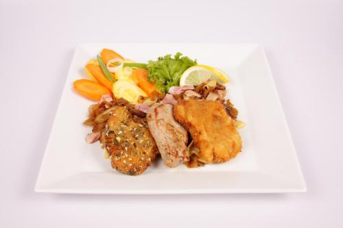 a white plate of food with chicken and vegetables at Oldtimer Motorhotel Guntramsdorf in Guntramsdorf
