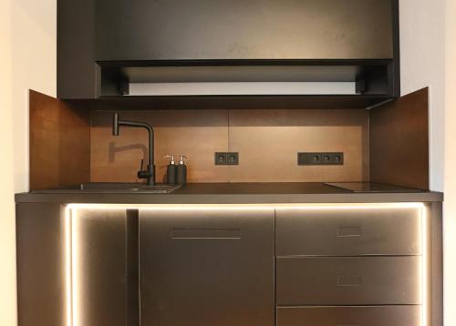 a stainless steel kitchen with a sink and a stove at Loft Apartment mit großer Badewanne A in Mügeln
