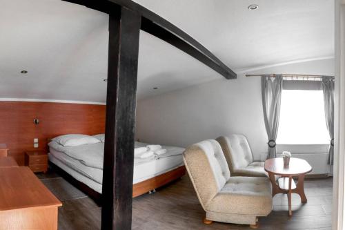 sypialnia z łóżkiem, krzesłem i stołem w obiekcie Usługi Noclegowe i Gastronomiczne dla Ludności Robert Mielcarek w Kobylej Górze