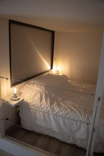 une chambre avec un lit blanc avec une fenêtre dans l'établissement Studio Oslo au cœur de la ville, à Boulogne-sur-Mer