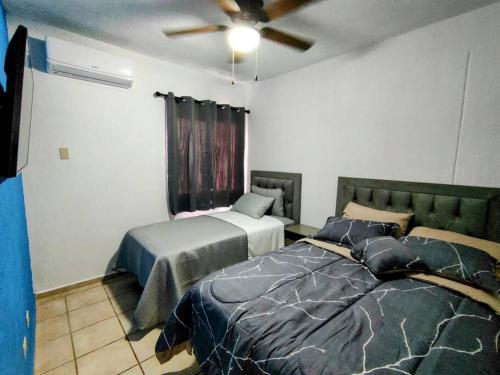 1 dormitorio con 2 camas y ventilador de techo en Casa Norte en La Paz