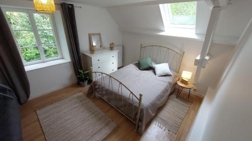 une petite chambre avec un lit et deux fenêtres dans l'établissement Maison La Rivière, à Reffuveille