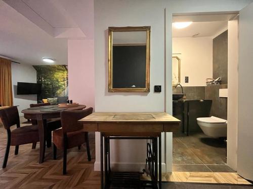 um quarto com uma mesa e uma casa de banho com um lavatório em Apartamenty Bursztynowa 36 em Niechorze