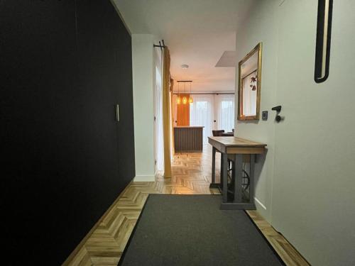 um corredor com uma secretária e uma mesa num quarto em Apartamenty Bursztynowa 36 em Niechorze