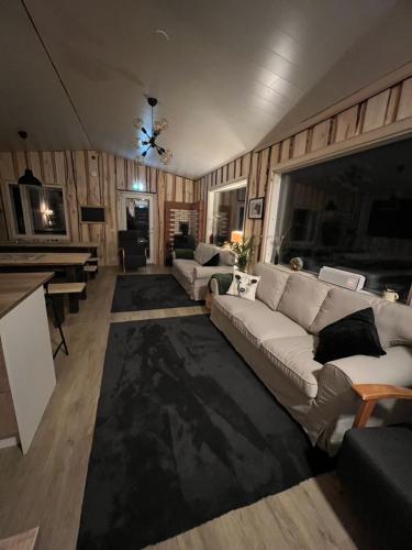 ein Wohnzimmer mit einem weißen Sofa und einem Klavier in der Unterkunft Elämyksellinen majoitus farmilla in Kälviä