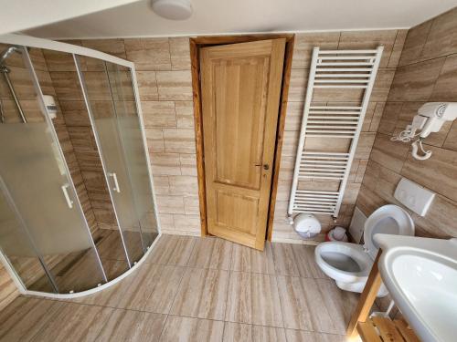 uma casa de banho com um chuveiro, um WC e um lavatório. em Casa Senik Monteoru em Merei
