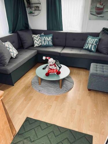 a living room with a couch and a coffee table at Chalet dans la forêt proche Disney in La Houssaye-en-Brie