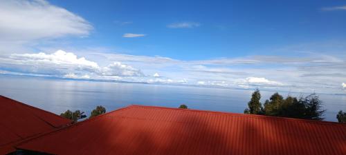 a view of the ocean from the roofs of houses at Taquile Lodge Inn in Huillanopampa