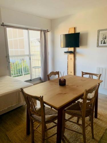 Cette chambre comprend une table et des chaises en bois ainsi qu'un lit. dans l'établissement Charmant studio rénové 3 couchages Arcachon centre ville, à Arcachon