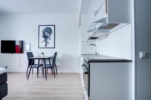 a kitchen with a sink and a table with chairs at Lapin Loiste 1, Modern studio, Free Parking and Wifi in Rovaniemi
