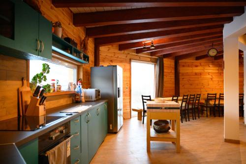 a kitchen with a refrigerator and a table with chairs at Chata Exit 