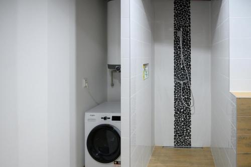 a bathroom with a washing machine in a room at Chata Exit 