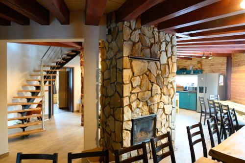 a stone fireplace in a dining room with a table and chairs at Chata Exit in Kolonica