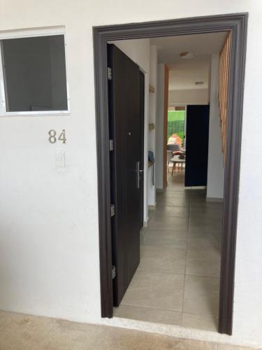 a hallway with two black doors and a hallway with a table at Casa familiar en condominio privado cerca de playa in Cancún