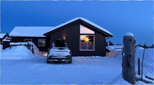 a car parked in front of a house in the snow at Beautiful cabin close to activities in Trysil, Trysilfjellet, with Sauna, 4 Bedrooms, 2 bathrooms and Wifi in Trysil