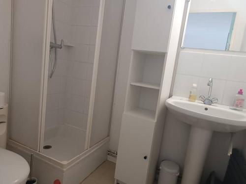 une salle de bain blanche avec une douche et un lavabo dans l'établissement Pavillon 5 personnes, à Port-la-Nouvelle