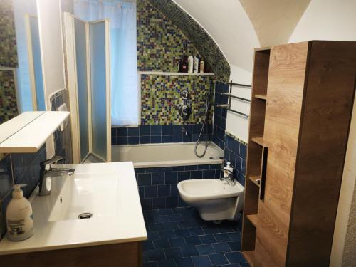 y baño con lavabo, aseo y bañera. en Appartamento sci & laghi "Tre Fontane", en Tione di Trento