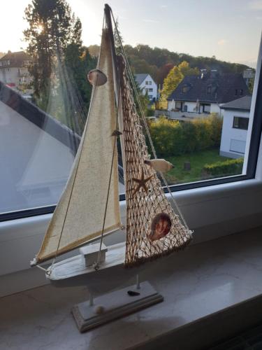 a model sailboat on a window sill at Kurparkhotel-Gemünd in Gemünd