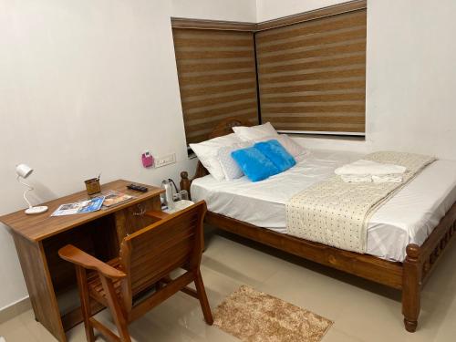 a bedroom with a bed with a wooden headboard and a desk at Happy Villa Homestay in Chelakara