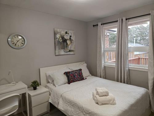 1 dormitorio con 1 cama y reloj en la pared en Spacious MBR Near Kennedy Subway & GO en Toronto
