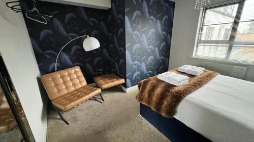 a bedroom with a bed and a chair and a lamp at Stunning Flat in Hull's Vibrant Fruit Market & Marina in Hull