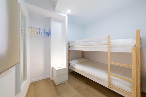 a room with two bunk beds and a lamp at Trendy Homes Lepanto I in Almería