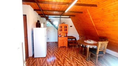 comedor con nevera y mesa en Cabañas Caranday, en Capilla del Monte