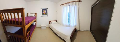 1 dormitorio con 2 literas y ventana en La più bella en Villa Carlos Paz