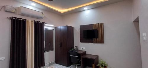 a living room with a tv and a bathroom at Mandakini Homestay in Varanasi