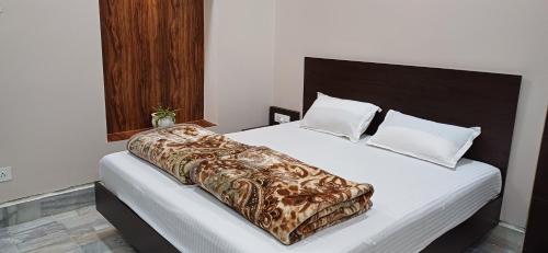 uma cama com um cobertor castanho e branco em Mandakini Homestay em Varanasi
