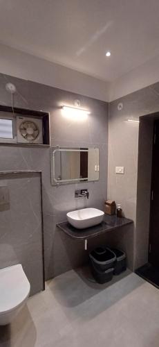 a bathroom with a white toilet and a sink at Mandakini Homestay in Varanasi