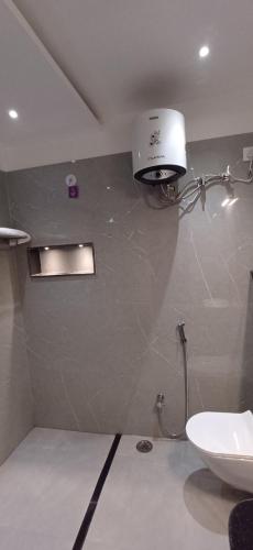 a bathroom with a toilet and a light on the wall at Mandakini Homestay in Varanasi