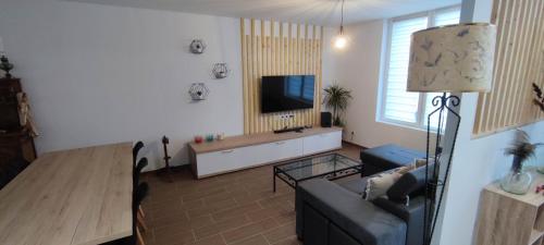 ein Wohnzimmer mit einem Sofa und einem Flachbild-TV in der Unterkunft Charmante maison de plain-pied in Rochefort