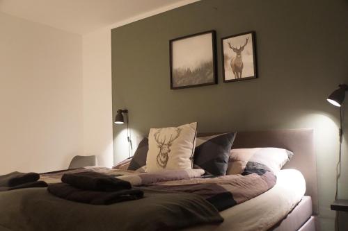 ein Schlafzimmer mit einem Bett mit zwei Bildern an der Wand in der Unterkunft Ferienwohnung Inheiden - Auszeit in Seenähe in Hungen