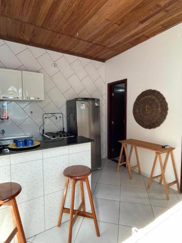 a kitchen with two stools and a table in it at Casinha Azul in Ilha de Boipeba