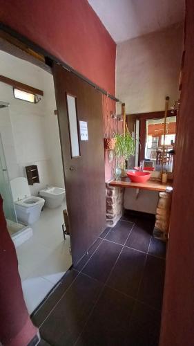 a bathroom with a toilet and a sink and a door at La Residencial in Humahuaca