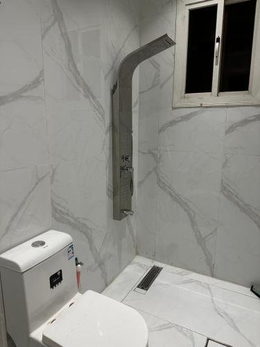 uma casa de banho branca com um WC e uma janela em شقة دخول ذاتي em Taif