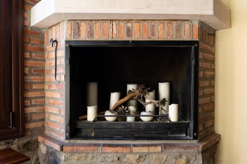 a fireplace with candles and christmas decorations in it at Casa del Agüelo in Cella