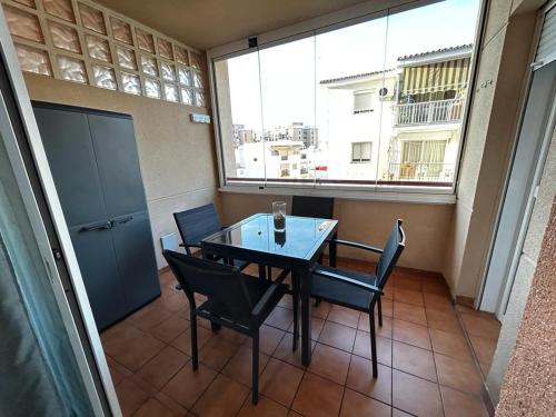 - une table et des chaises dans une chambre avec fenêtre dans l'établissement Apartamento Elena, à Fuengirola