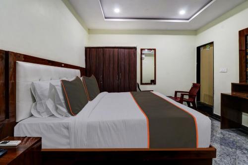 a bedroom with a large bed and a desk and chair at Collection O B SQUARE VILLA in Visakhapatnam