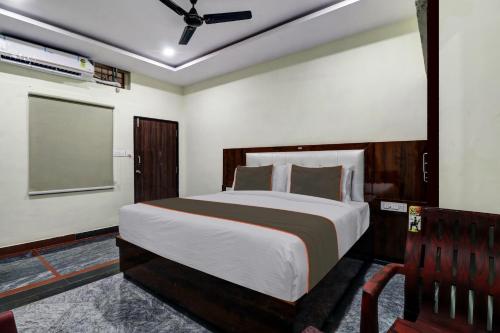 a bedroom with a large bed and a chair at Collection O B SQUARE VILLA in Visakhapatnam