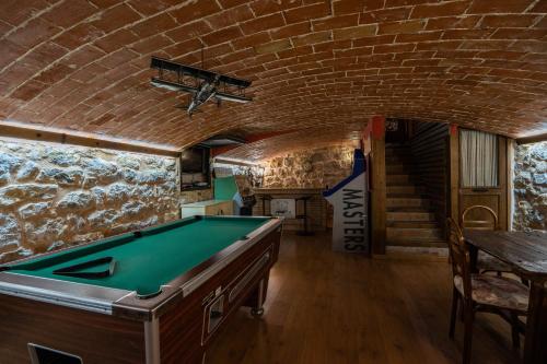 Habitación con mesa de billar y pared de ladrillo en Casa del Agüelo en Cella